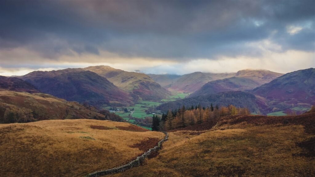 Autumn light over a Lake District valley with a drystone wall, Cumbria, in September